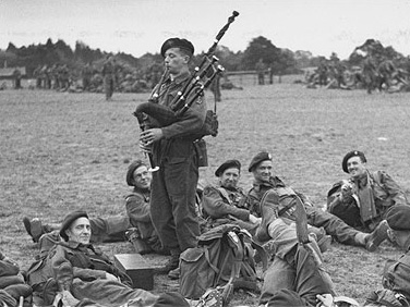 Bill Millin plays his pipes for fellow soldiers in 1944