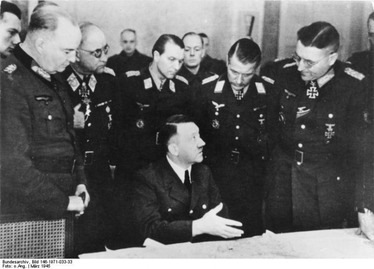 Theodor Busse (standing, far right) in a meeting with Hitler, March 1945 Bundesarchiv, Bild 146-1971-033-33 / CC-BY-SA 3.0