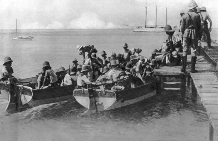 Emden’s landing party going ashore on Direction Island; the three-masted Ayesha is visible in the background