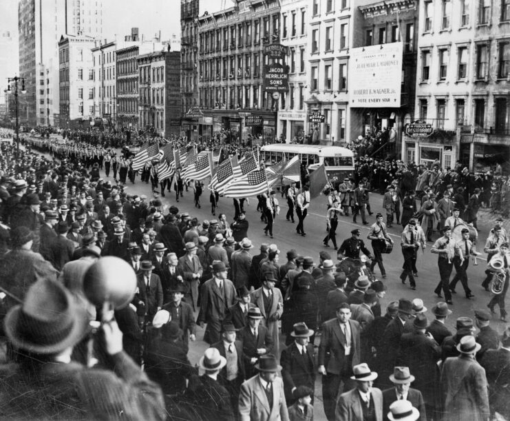 Crowds gathered along a street to watch a German American Bund parade