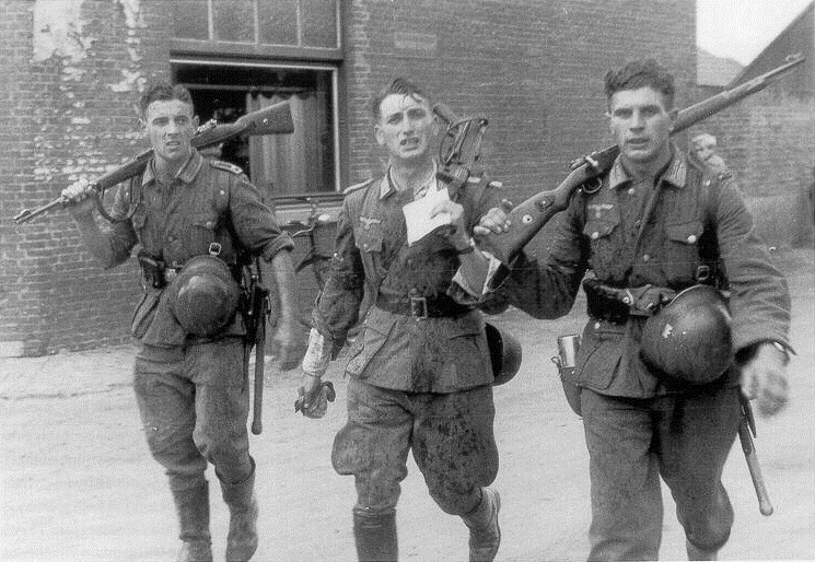 Three German soldiers returning from training exercise, France, October 1941.