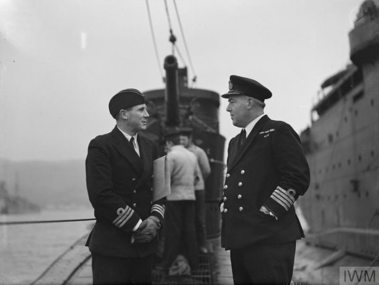 Commander G M Sladen, DSO, DSC, RN, Captain of HMS TRIDENT (left) in conversation with Captain H M C Ionides, RN, Captain S3, after the arrival of the TRIDENT alongside the Depot ship.
