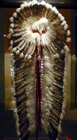 National Cowboy & Western Heritage Museum ( Oklahoma City ). Cree trailer headdress ( ca. 1940 ), made of red wool cloth, ribbon, eagle feathers, plume feathers, glass beats, raw hide and felt head.Photo Wolfgang Sauber CC BY-SA 3.0