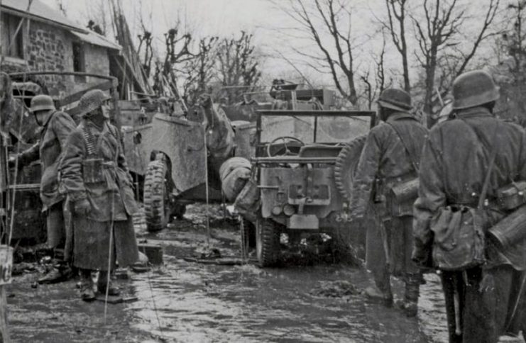 Panzergrenadiers of the 1st SS Panzer Division look through abandoned American equipment at Hosfield, Belgium.