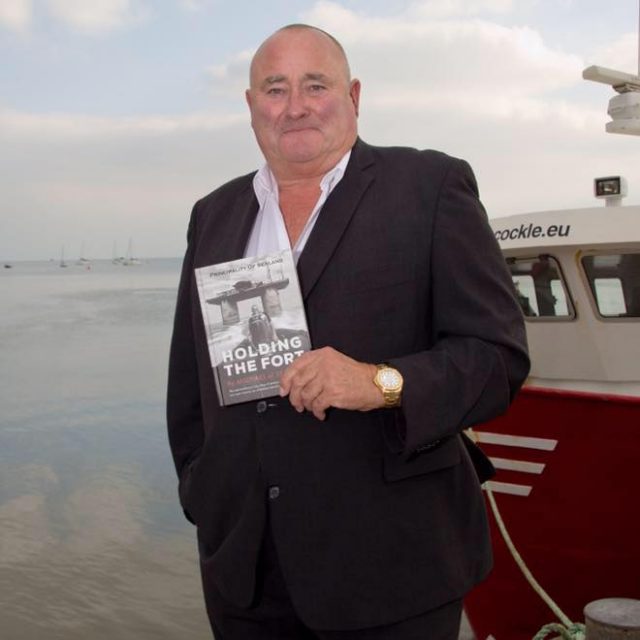 Michael Bates, current Prince of the Principality of Sealand, posing with his book