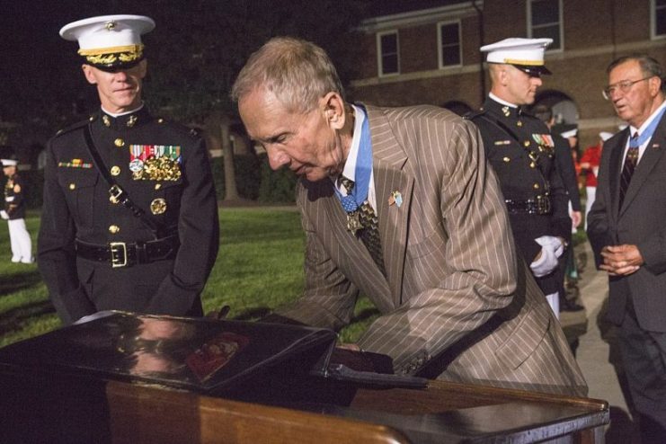 Retired U.S. Marine Corps Maj. Gen. James E. Livingston, Medal of Honor recipient, signs the guest book after the evening parade at Marine Barracks Washington, Washington, D.C., Aug. 5, 2016.