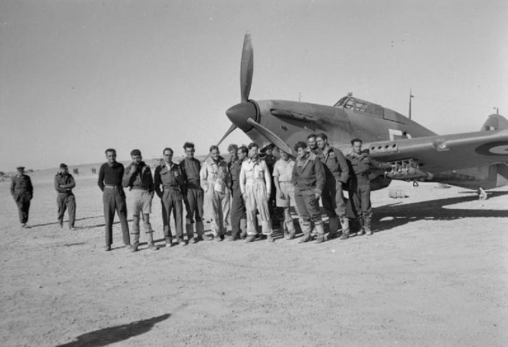 Pilots of No. 80 Squadron RAF gather in front of one of their Hawker Hurricane Mark Is at a landing ground in the Western Desert, during Operation CRUSADER. (RAF Operations in the Middle East and North Africa)