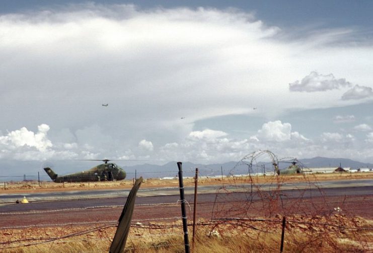 Two U.S. Marine Corps Sikorsky UH-34D Seahorse helicopters on the runway at Đông Hà, Quang Tri Province, Vietnam, in 1967. A Boeing-Vertol CH-46 Sea Knight and two Bell UH-1 Huey helicopters are airborne in the background.