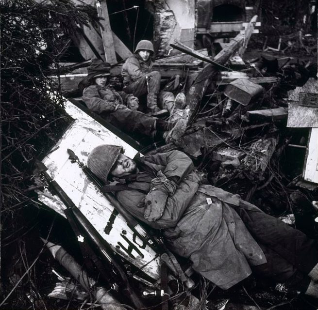 U.S. soldiers pause for a rest among the ruins of the Siegfried Line in the Rhine Valley, February 1945.