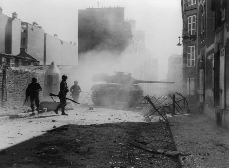 US tank destroyer M36 fires its 90mm gun point-blank at a Nazi pillbox emplacement to clear a path through a side street in Brest, France.