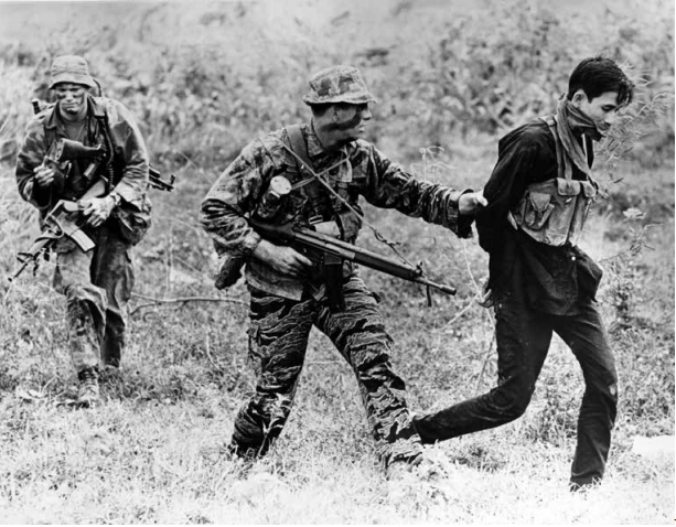 US Navy SEALs Terry Sullivan, left, and Curtis Ashton with a captured Viet Cong in the My Tho area, 1969.