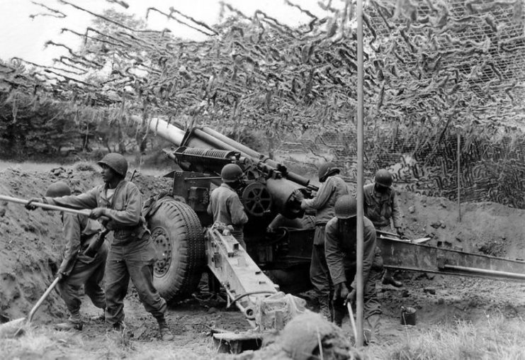Artillerymen of the 333rd Field Artillery Battalion emplace their 155 mm howitzer