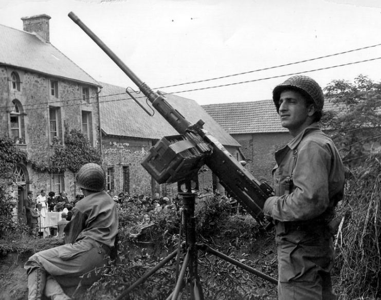 A U.S. soldier in Normandy stands guard with the M2HB installed on a dual-purpose mounting.