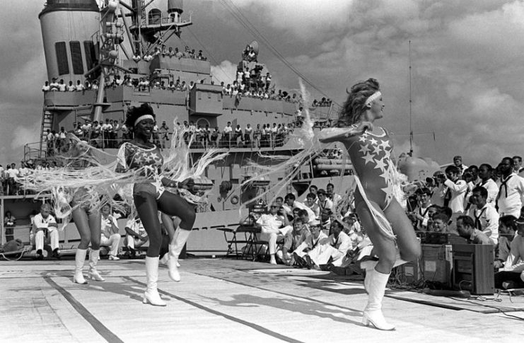 The Dallas Cowboys Cheerleaders (1983) performing in the USO show “America and Her Music” on the deck of the nuclear-powered guided missile cruiser USS Bainbridge (CGN-25)