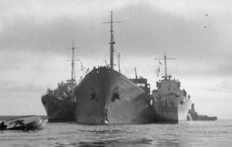 The damaged tanker SS Ohio, supported by Royal Navy destroyers HMS Penn (left) and Ledbury (right).