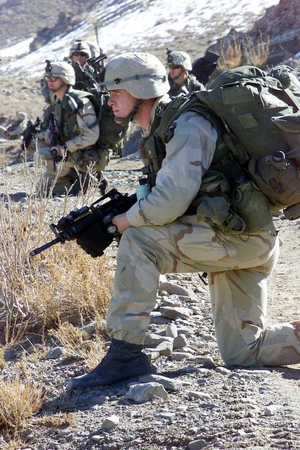 A U.S. soldier with 1st Battalion, 187th Infantry Regiment, 101st Airborne Division (Air Assault), watches for enemy movement during a pause in a road march during Operation Anaconda, March 2002.