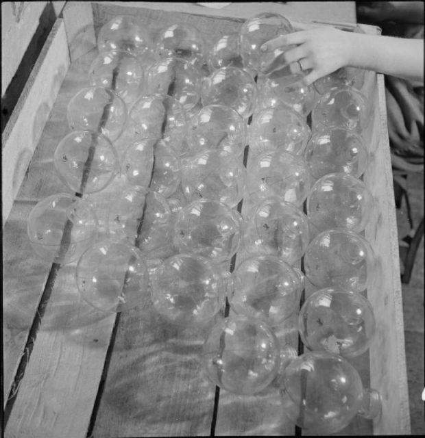 A boxful of glass flasks, which will form the main body of the sticky bomb, are inspected and approved at the workshop where the bombs are assembled, somewhere in Britain.