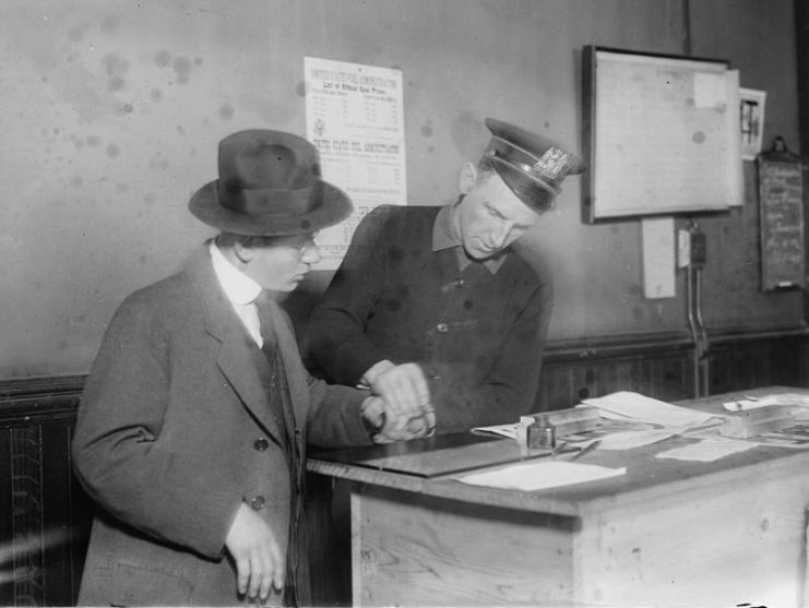 A New York City Police officer fingerprinting a German in 1917.