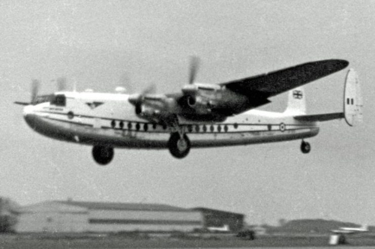 Avro York of the based Air Charter Ltd taking off on a trooping flight in 1955 with wartime hangars in the background