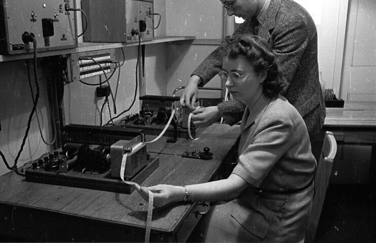 BBC employee holding a strip of Morse code while sat at a table