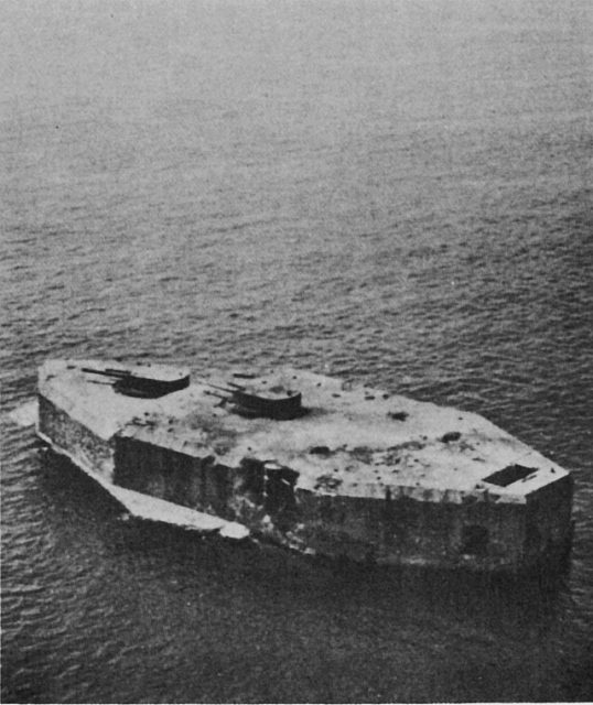 Fort Drum in the harbor of Manila Bay pitted by bombs following an aerial and surface barrage by Japanese and U.S. forces.