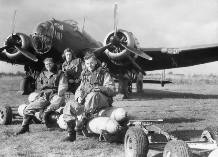 Handley Page Hampden of No. 83 Squadron with crew, seated on a loaded bomb trolley at Scampton, October 1940