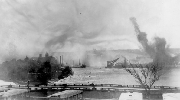 HMS Illustrious under Ju 87 attack in the Grand Harbour. The carrier is to the right of the large crane