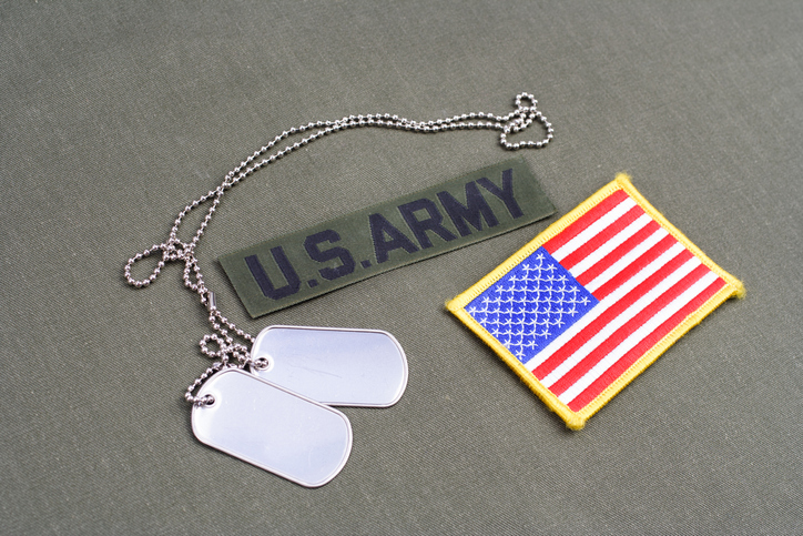 US ARMY Branch Of Service Tape with dog tags on olive green uniform.
