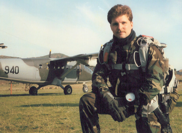 John Chapman kneeling before an aircraft