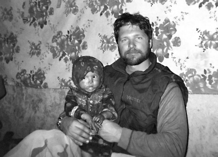 John Chapman sitting with an Afghan child
