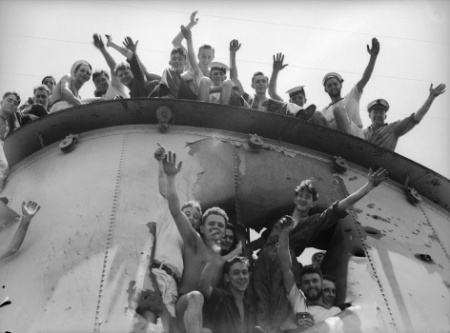 Sailors from Sydney posing around and in the forward funnel shellhole. This was the only damage received by the Australian cruiser during the battle of Cape Spada.