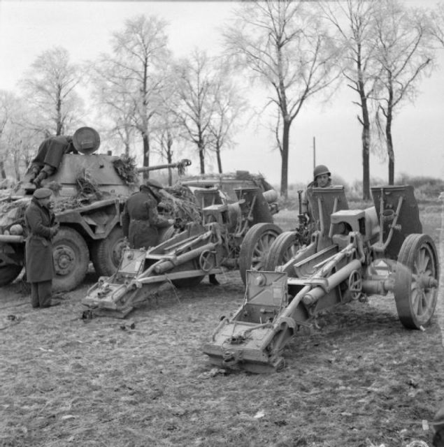 British and American troops inspect captured German guns and a Puma armoured car, near Foy Notre Dame, 29 December 1944.