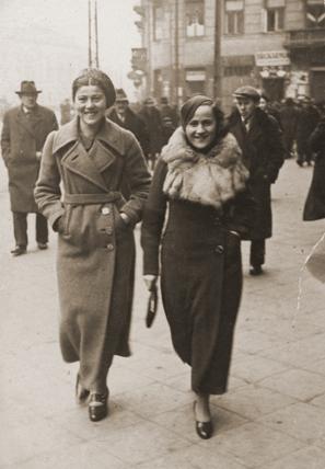 Ita Rozencwajg/Ita Rosenzweig and her cousin Frieda Belinfante walk down a street in Warsaw/Poland.
