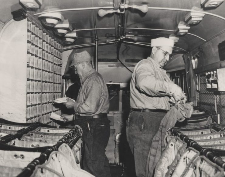Two Highway Post Office clerks sort mail inside the first Highway Post Office bus.1941