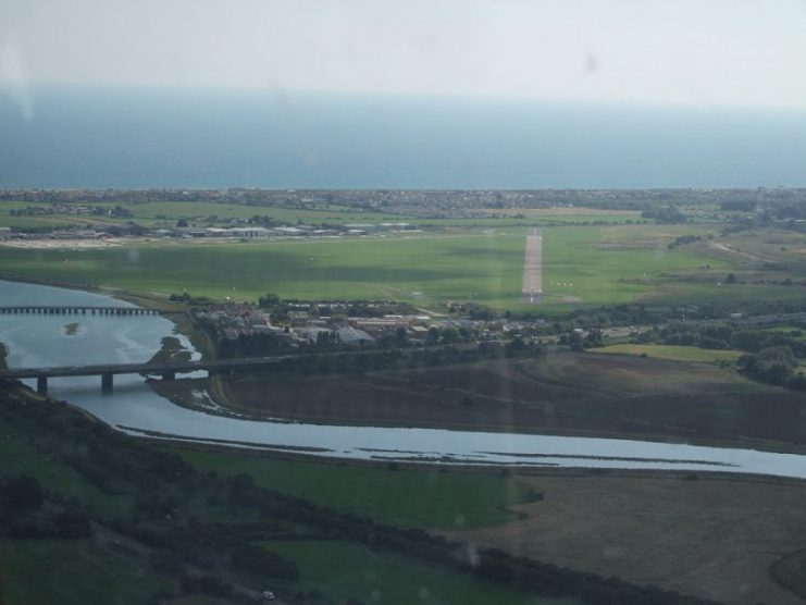 Aerial view looking south-west towards Shoreham airport. The aircraft hit the A27 dual-carriageway between the River Adur, in the foreground, and the runway.