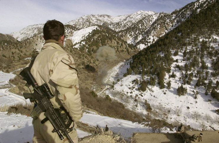 Eastern Afghanistan (February 12, 2002) – A Navy SEAL observes munitions being destroyed. The SEALs discovered the munitions while conducting a Sensitive Site Exploitation (SSE) mission in Eastern Afghanistan.