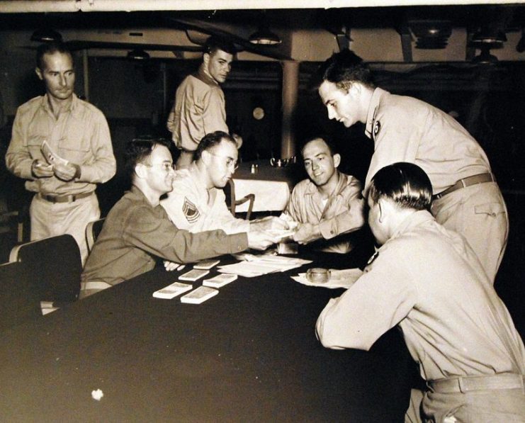 Operation Dragoon, August 1944. Finance Officer of Seventh Army exchanges new invasion francs for the gold-seal overseas dollar of officers who are to go ashore in the assault on Southern France the next day.