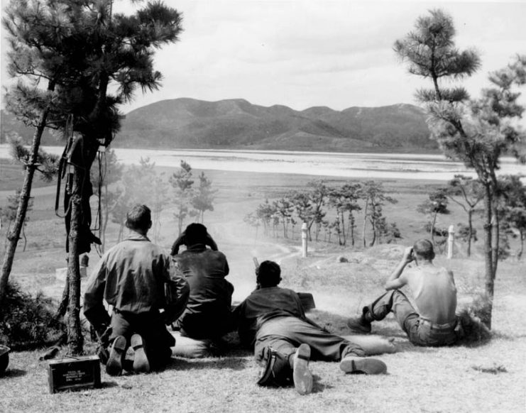 A .50 Cal. Machine gun squad fires on North Korean patrols along the north bank of the Naktong River, Korea.