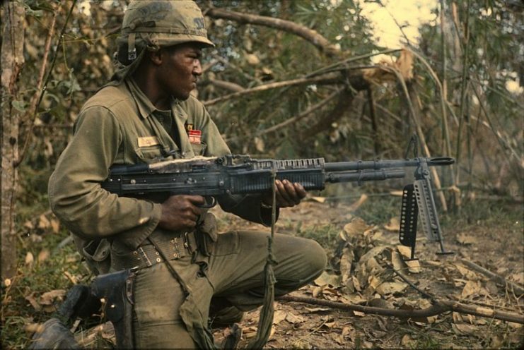 25th Infantry Division soldier spraying tree line with M60 fire