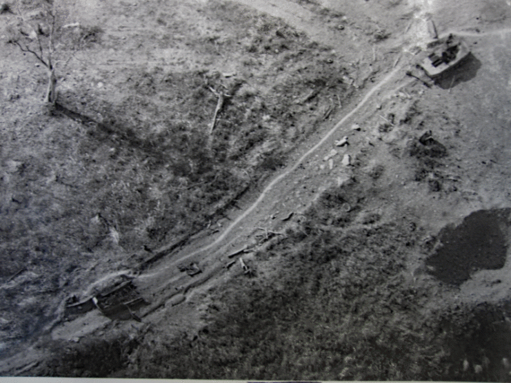 A PT-76 tank, destroyed by American anti-tank weapons, lies dormant along a road after the battle at the Lang Vei Special Forces Camp