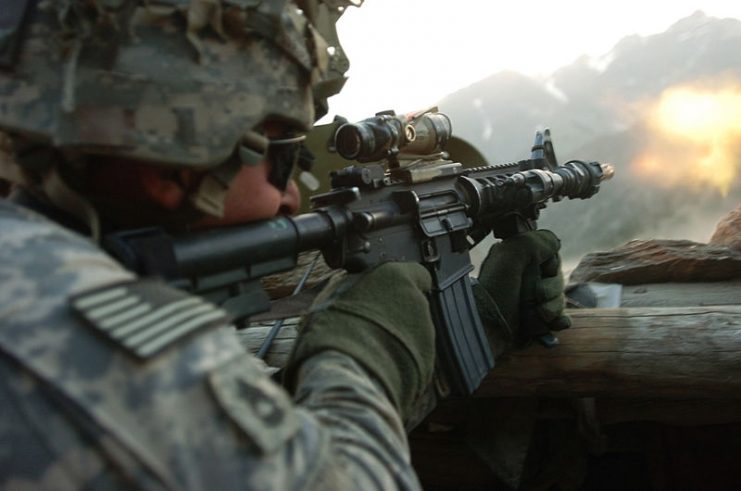 A U.S. Army Soldier with 1st Battalion, 32nd Infantry Regiment, 10th Mountain Division, fires an M4 rifle during a gun battle with insurgent forces in Barge Matal, during Operation Mountain Fire.