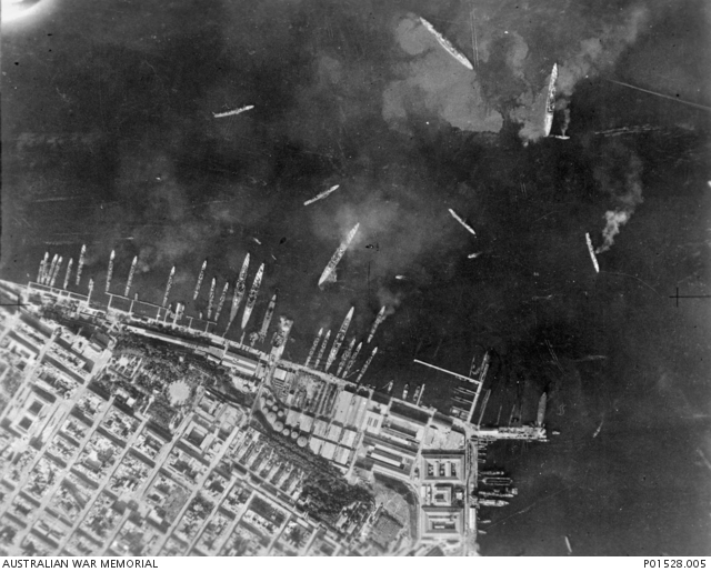 Aerial view of the inner harbor showing damaged Trento-class cruisers surrounded by floating oil.