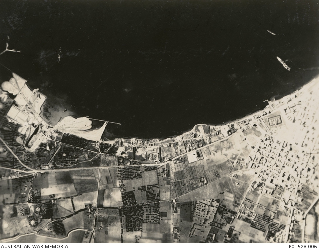 Aftermath of the battle showing an Italian battleship down by the bows and beached (far right).