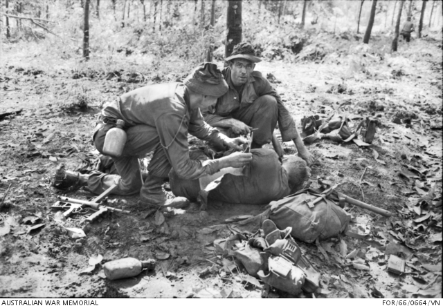 Medic providing first aid to wounded Australian soldier at Long Tan (AWM FOR660664VN)