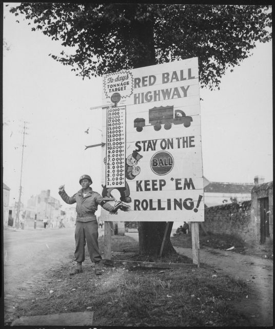 Military Police soldier and sign posted along the Red Ball route