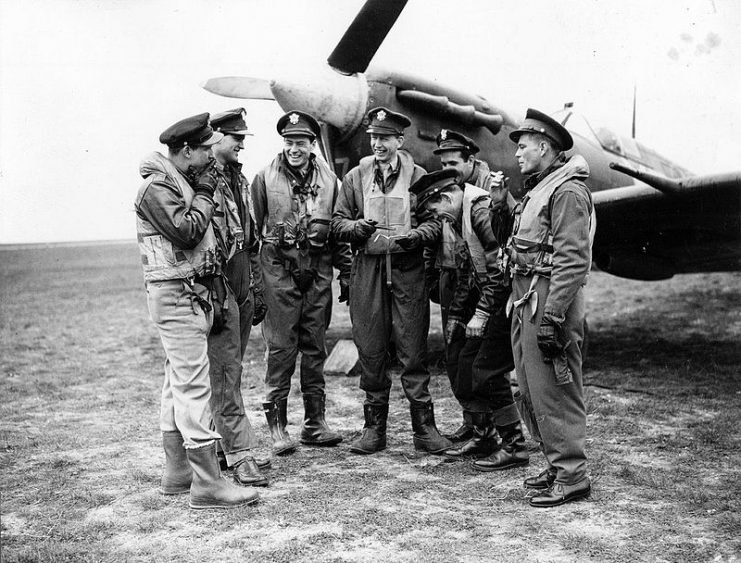 Pilots from the 4th Fighter Group sharing a smoke in front of a Spitfire at Debden air base.