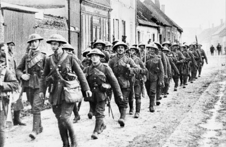 A platoon of ‘D’ Company of the 7th Battalion, Bedfordshire Regiment passing through a French village on its way to the line, shortly before the start of the offensive.