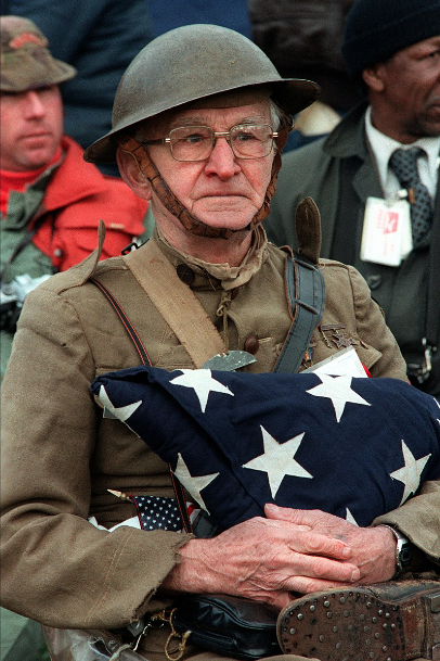 Joseph Ambrose, an 86-year-old World War I veteran, attends the dedication day parade for the Vietnam Veterans Memorial in 1982. He is holding the flag that covered the casket of his son, who was killed in the Korean War