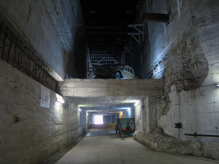 Interior of the 16 m (52 ft)-high servicing hall. V-2s would have been moved through here en route to the launch pads. The floor level has been raised in recent years to prevent flooding; it would originally have held a railway line.Photo: Prioryman CC BY-SA 3.0