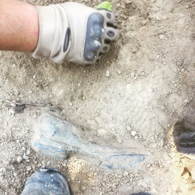 A Red Army soldier, my boot and his boot. The soldier was one of around 60 soldiers found at the side of a road in Latvia. After the battle had ended, they were piled into a hole. I worked alongside a group from Russia to carefully remove them.